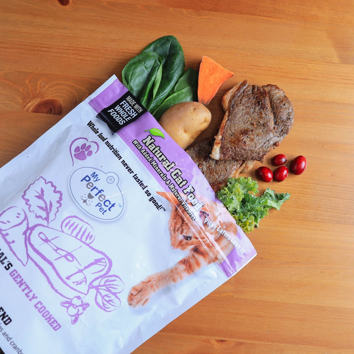 Package of Bengal's Beef Carnivore with fresh whole foods spilling out on a wooden table